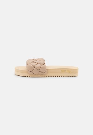 Beige slidesandal med en bred, vævet polstret rem og en formet sål med indgraveret "flip*flop" på siden.
