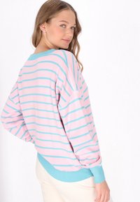 Roze en blauwe gestreepte trui met een ontspannen fit, geribbelde manchetten en een effen blauwe zoom. Zachte textuur, ronde halslijn, lange mouwen.