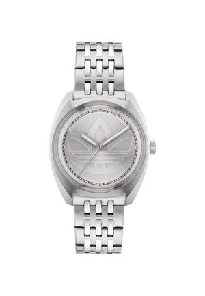 Montre en métal argenté avec un boîtier rond, un cadran texturé et un logo gravé. Elle est dotée d'un bracelet à maillons et de simples aiguilles argentées.