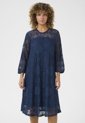 Navy blue lace dress with three-quarter sleeves, featuring a floral pattern and scalloped neckline, made of lightweight, textured fabric.