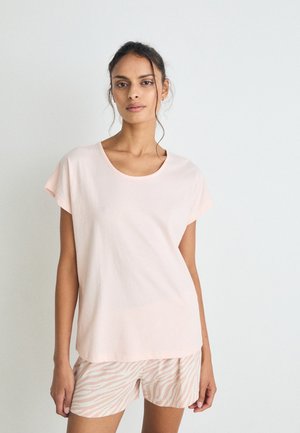 Lichtroze katoenen T-shirt met een ronde hals en korte mouwen, gecombineerd met lichte shorts met een subtiel zebrapatroon in beige.