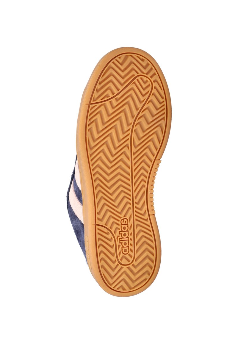 Semelle de basket en daim bleu marine avec une semelle extérieure en caoutchouc gomme texturée, présentant des motifs à chevrons et le logo "adidas" embossé.
