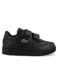 Fekete bőrsneaker tépőzáras pántokkal, zöld Lacoste logó hímezve és texturált gumi talppal. Alacsony profilú dizájn.