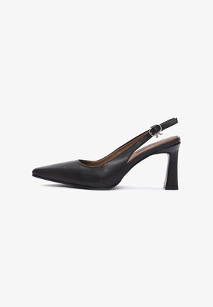 Talons hauts slingback en cuir noir avec un bout pointu, un talon carré de 3 pouces et des accessoires en argent décoratifs sur la bride de cheville. Texture lisse.