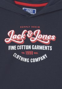 Felpa navy con cappuccio foderato di rosso, dotata di una grafica centrale in bianco e rosso con la scritta "Jack & Jones Fine Cotton Garments."