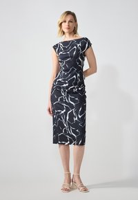 Knee-length kleit, mis on valmistatud tumesinine taust ning valged abstraktsed mustrid; varrukateta ja keha lähedane siluett.