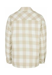 Chemise à carreaux beige et blanche. Manches longues avec poignets boutonnés, col et détail de l'empiècement arrière. Texture de tissu doux tissé.