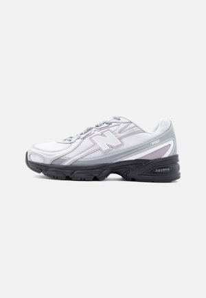 Chaussure de course New Balance blanche et grise avec semelle noire et amorti ABZORB, vue de côté sur un fond clair uni.