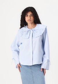 Chemise rayée bleue et blanche avec un grand col brodé, fermeture à boutons à l'avant et poignets à cordon pour un ajustement réglable.