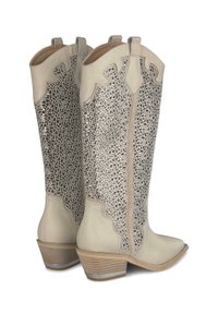 Stivali da cowboy beige con brillanti strass che coprono la parte anteriore, design ondulato, punta appuntita e tacco impilato con un accento argentato.