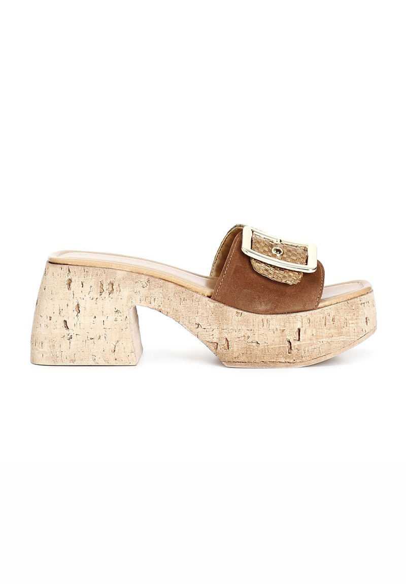 Brown suede wedge mules with a cork platform, featuring a metallic buckle and textured strap, showcasing a rounded toe and block heel design.
