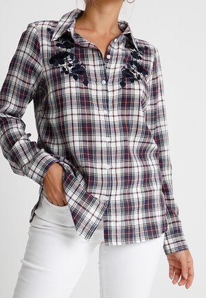 Camicia a quadri in cotone con colori blu navy, rosso e bianco; presenta ricami floreali sul colletto, chiusura con bottoni e maniche lunghe.
