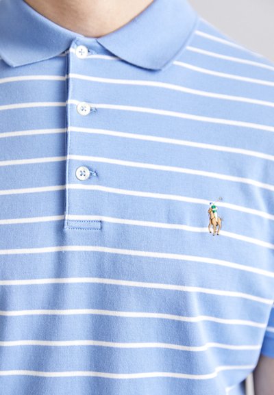 Γαλάζιο πικέ μπλουζάκι με λευκές οριζόντιες ρίγες, με τριπλό κουμπί και μικρό κεντημένο λογότυπο στο αριστερό στήθος.