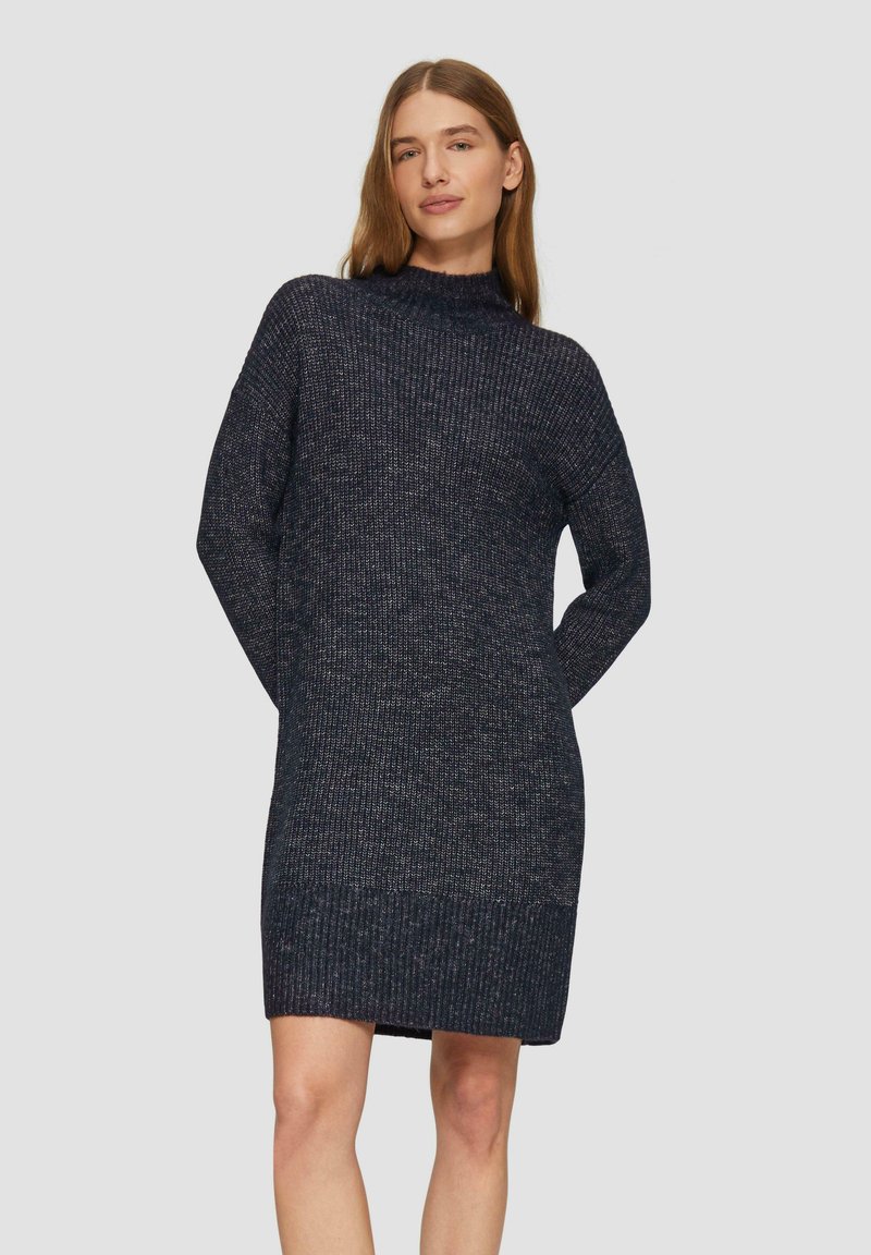 Robe pull en maille bleu marine foncé avec un col haut, des manches longues et un ourlet côtelé. Le matériau présente une texture variée avec un motif subtil.
