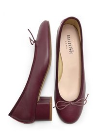 Ballerines en cuir bordeaux avec un bout arrondi, un petit talon carré et un nœud décoratif à l'avant. Doublure intérieure douce et coutures minimales.