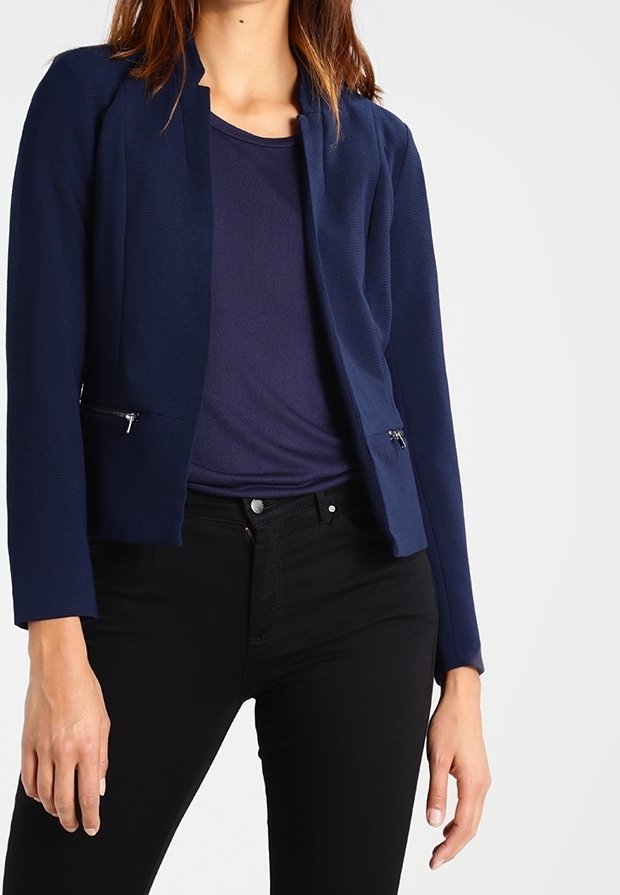 Námořnický modrý zapínací blazer s přiléhavým střihem, texturovaná tkanina, dvě přední zipové kapsy, v kombinaci s námořnickým topem a černými kalhotami.