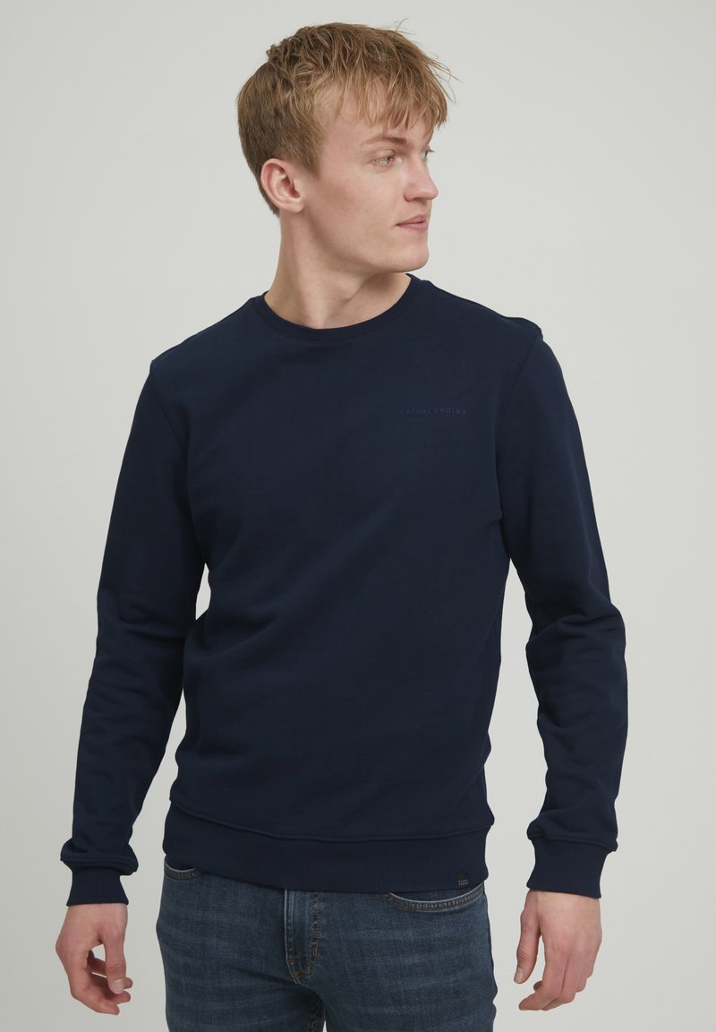 Sweatshirt bleumarin, cu guler rotund, mâneci lungi, fabricat dintr-un amestec de bumbac. Prezintă manșete și tiv ribbed, detaliu subtil cu logo pe piept.