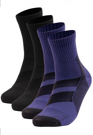 Zwei Paar Knöchelsocken, ein schwarzes Paar und ein lilafarbenes Paar mit schwarzen Akzenten, nebeneinander auf weißem Hintergrund dargestellt.