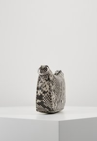 Teksturowana torebka z materiału syntetycznego z szaro-czarnym wzorem węża. Charakteryzuje się smukłym, prostokątnym kształtem i srebrnym pierścieniem jako akcentem.