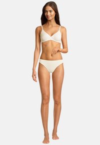 Reggiseno beige chiaro e bikini coordinato, design senza cuciture, tessuto morbido, sottili spalline regolabili sul reggiseno, stile minimalista.