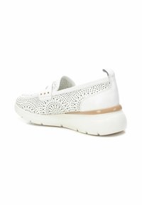 Sneaker bianco slip-on con tomaia perforata, sottili accenti beige sulla suola e una suola bianca spessa per l'ammortizzazione.