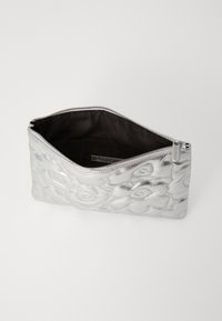 Bolsa metálica plateada con patrón floral en relieve, cierre de cremallera y forro interior oscuro. Compacta, textura suave, forma rectangular.