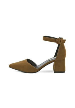 Scarpa alta in suede marrone con punta affusolata, cinturino alla caviglia con dettaglio di bottone tondo e tacco a blocco spesso.