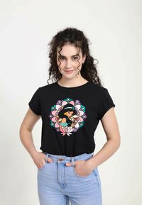 Sort t-shirt med et farverigt trykt design af en karakter inden for et blomster-mandalamønster. Korte ærmer og afslappet pasform.