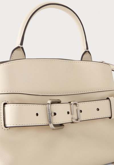 Sac à main en cuir crème avec poignée supérieure et large bandoulière ceinture avec boucle argentée gravée "Marc Jacobs".