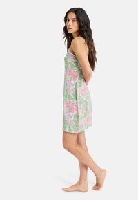 Light green dress with pink floral pattern, spaghetti straps, knee-length hem, and soft, lightweight fabric.