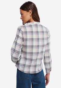 Een geruite overhemd van zacht stof, met een patroon in lichtgrijs, blauw en bordeauxrood, met lange mouwen en knoopmanchetten.