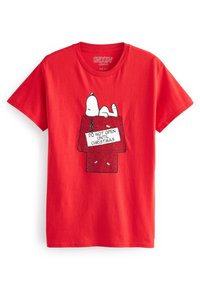 Červené bavlněné tričko se grafikou Snoopyho ležícího na dárkové krabici s nápisem "NEOTVÍREJTE PŘED VÁNOCI" v černém písmu.