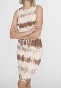 Sukienka do kolan, bez rękawów, w kolorze kremowym z brązowymi paskami tie-dye. Wykonana z materiału o prążkowanej fakturze, charakteryzująca się dopasowanym krojem i miękką substancją.