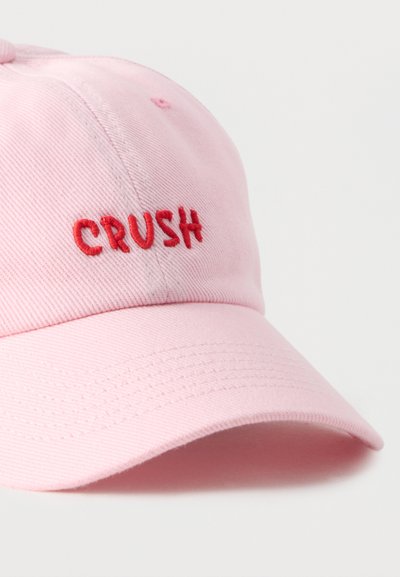 Ροζ καπέλο του μπέιζμπολ με κόκκινη κεντητή λέξη «CRUSH» στο μπροστινό μέρος, με ορατές ραφές στο γείσο και τα πάνελ.
