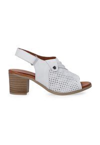 Weiße Leder-Slingback-Sandale mit perforiertem Design, offener Zehenpartie und beigem Blockabsatz. Mit Knopf-Akzent und verstellbarem Riemen.