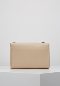 Beige rechthoekige handtas van gestructureerd synthetisch materiaal, met een vergulde kettingriem en strakke lijnen zonder zichtbare logo's.