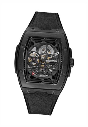 Montre squelette noire avec un boîtier rectangulaire, affichant un cadran transparent, un mouvement complexe et un bracelet en cuir noir texturé.