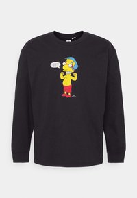 Mustat pitkähihainen t-paita, joka on valmistettu puuvillasta. Paidassa on sarjakuvahahmo, joka käyttää keltaista paitaa ja punaisia shortseja, ja siinä on puhekupla.