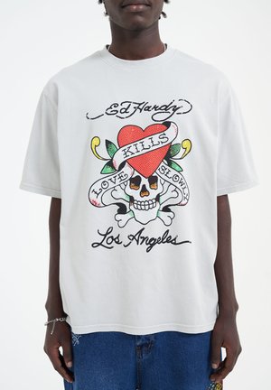 Lys grå Ed Hardy t-shirt med grafisk design, der viser et hjerte, et kranium og teksten "Love Kills Slowly". Korte ærmer, lavet af bomuldsstof.