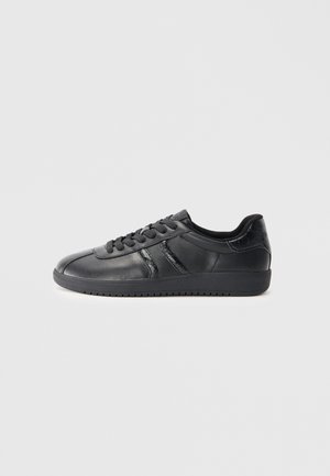 Sneakers in pelle nera con una texture liscia, dotati di lacci, punta arrotondata e un accento laterale testurizzato. Suola in gomma con grip.