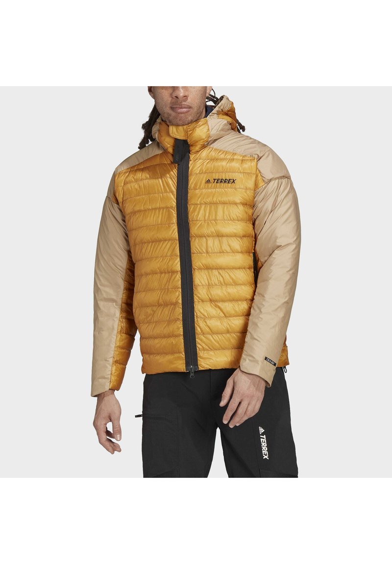 Gelb und beige Puffjacke mit Reißverschluss, Kapuze und schwarzen Akzenten. Verfügt über ein gestepptes Design und das Terrex-Logo auf der Brust.