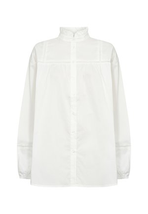 Balta ilgomis rankovėmis mygtukų marškiniai su aukštu apykakle, raukšlių priekyje ir surinktomis rankovėmis. Pagaminta iš lengvo medvilnės audinio.