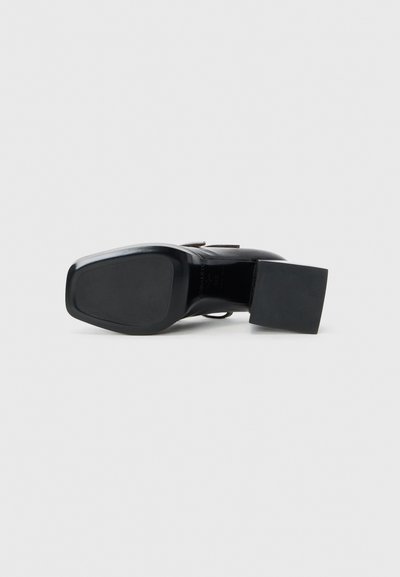 Chaussure à talon en cuir noir avec un bout carré et un talon carré. Texture lisse avec un matériel minimal et un design épuré.