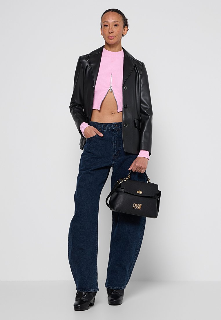 Blazer en simili cuir noir, top cropped rose à côtes avec fermeture éclair, jeans taille haute bleus, sac à main noir avec accents dorés, chaussures à plateforme.