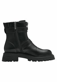 Bottine en cuir noir avec une semelle épaisse, dotée d'une fermeture éclair sur le côté, de larges sangles et d'une texture de surface lisse.