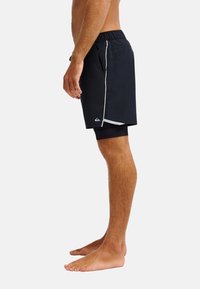 Μαύρο μαγιό βερμούδα με κορδόνι στη μέση, που διαθέτει πλαϊνή τσέπη, λευκή διακοσμητική ρίγα και λογότυπο στο κάτω μέρος του ποδιού. Η υφή του υφάσματος είναι λεία.