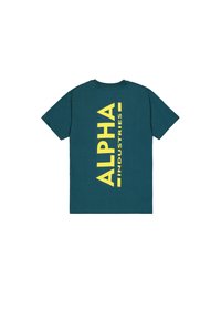 Türkisfarbenes Kurzarm-T-Shirt mit großem vertikal verlaufendem gelbem "ALPHA INDUSTRIES"-Schriftzug auf der Rückseite vor weißem Hintergrund.