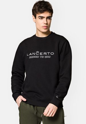 Czarna bluza crewneck z białym tekstem logo "LANČERTO" oraz "DRIVEN TO WIN." Posiada ściągacze przy rękawach i na dole, wykonana z miękkiego materiału.