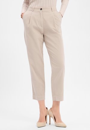 Beige Hose mit maßgeschneiderter Passform, mit Falten, Seitentaschen und Knopfverschluss. Der Saum ist verkürzt und ergänzt spitze, nudefarbene Absätze.