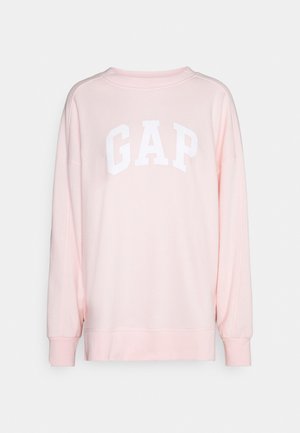 Pink sweatshirt with long sleeves, rounded neckline, and white "GAP" logo across the chest. Made of soft fabric with a relaxed fit.